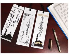 three bookmarks with writing on them next to a pen