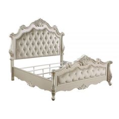 a white bed with an ornate headboard and foot board is shown in this image