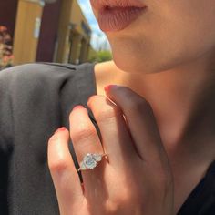 a close up of a person wearing a ring with a diamond on it's finger