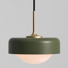 a green and gold pendant light with a black cord hanging from it's end