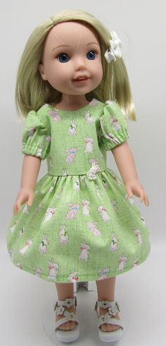 a doll with blonde hair wearing a green dress