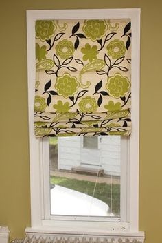 the window is decorated with green and yellow flowers on it's valance,