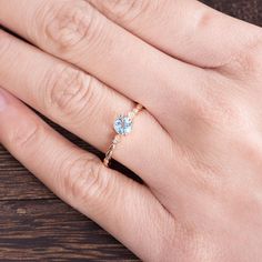 a woman's hand with a ring on it and a blue stone in the middle