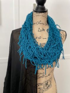 a mannequin wearing a blue scarf on top of a wooden dummy with writing on it