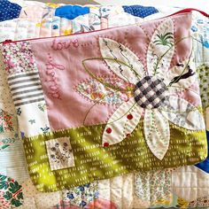 a close up of a patchwork pillow on a bed