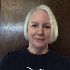 an older woman with white hair wearing a black shirt