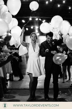 a man and woman are holding balloons in the air