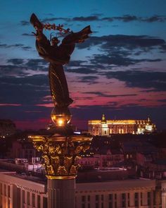 a statue on top of a building in the evening