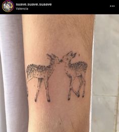 a couple of deers on the arm, with one being touching each other's forehead