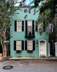 a blue house with black shutters and windows