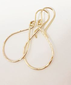 "Sleek and petite tear drop shaped hoops suspended from gold filled ear wires. Tear drop hoops is handmade with precious metal wire then hammered to textures and shine. Hoops is measure about 3/4\" x 1 inches in sizes. Hand shaped gold filled French ear wires." Brass Teardrop Earrings With French Hook, Nickel-free 14k Gold Filled Teardrop Earrings, Everyday Hand Forged Teardrop Earrings, Teardrop Hoop Earrings With French Hook, Dainty Hammered Teardrop Earrings, Minimalist Teardrop Hoop Earrings With Ear Wire, Handmade Teardrop Yellow Gold Hoop Earrings, Handmade 14k Gold-filled Teardrop Earrings, Yellow Gold Teardrop Hoop Earrings With Ear Wire