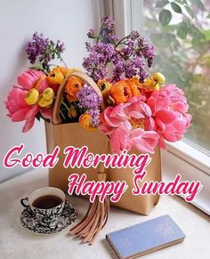 a bouquet of flowers sitting on top of a table next to a cup and book