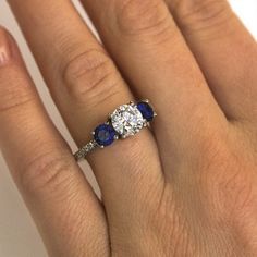 a woman's hand with a diamond and sapphire ring