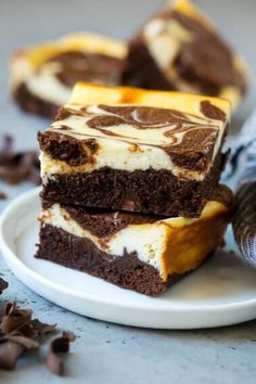 three pieces of cake sitting on top of a white plate next to a chocolate cookie