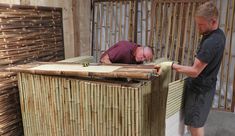 two men are working on some kind of bamboo structure that looks like it has been made out of wood