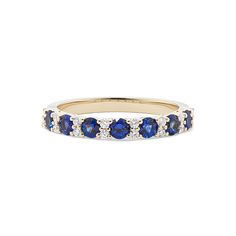 a yellow gold ring with blue and white stones on the sides, set against a white background