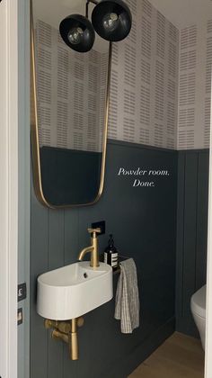 a white sink sitting under a bathroom mirror next to a wall mounted faucet