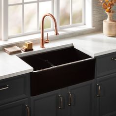 a black kitchen sink sitting under a window