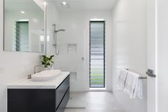 Simple white bathroom with black cabinetry Framed Bathroom Mirror