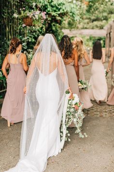 a bride and her bridal party walking down the aisle