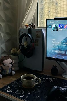 a desktop computer monitor sitting on top of a desk next to a cup of coffee