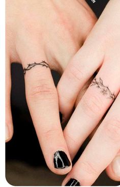 two people with tattoos on their fingers