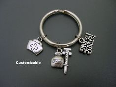 "Nurse Keychain / Nurses Call the Shots / Medical Assistant Keychain / Nursing Student Keychain / Nurse Key Ring / Gift for Nurse  All my keychain are customizable - if you want to add or exchange a charm, add a letter, number, or a birthstone, please contact me before placing your order. This keychain was handmade with nurse cap, syringe and \"nurses call the shots\" charms.   Your choice of - small key ring  - 1\" (2.5cm) diameter - large key ring - 1.2\" (3.2cm) diameter Add an initial charm  https://www.etsy.com/ca/listing/454708888/add-on-charm-add-a-personalized-initial?ref=shop_home_active_1 Check out my other keychains https://www.etsy.com/ca/shop/Trend4Ever?ref=hdr_shop_menu&section_id=7767364 Please contact me if you have any questions. Thank you for looking and have a great day! Silver Keychain With Lobster Clasp, Personalized Silver Keychain For Personal Use, Personalized Silver Keychain, Large Key Rings, Nurse Keychain, Nurse Cap, Nursing Cap, Gift For Nurse, Medical Assistant