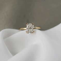 a close up of a diamond ring on a white cloth