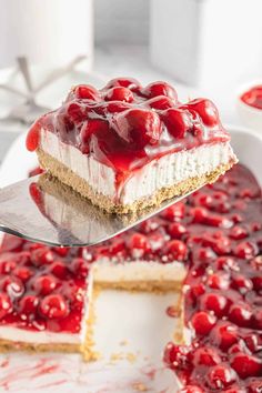 a piece of cheesecake with cherries is being lifted from the cake