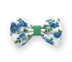 a white bow tie with blue flowers on the front and green trim around the bottom