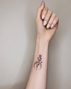 a woman's arm with a small flower tattoo on the left side of her wrist