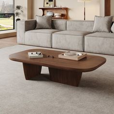 a living room with a couch, coffee table and large window looking out onto the yard