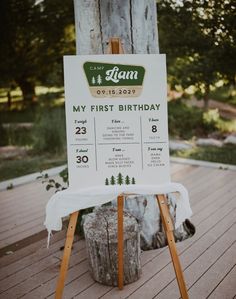 a sign that is sitting on top of a wooden stand in front of a tree