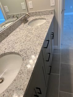 a bathroom counter with two sinks and a door leading to the outside patio area in the background