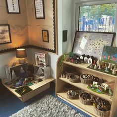 two shelves filled with toys and pictures on the wall next to each other in front of a window