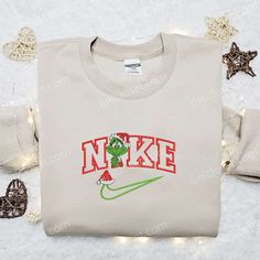 Introducing the Grinch Christmas x Nike Movie Embroidered Tshirt, a perfect blend of festive cheer and iconic style. Made with premium quality fabric, this Nike inspired shirt showcases intricate embroidery of the beloved Grinch character. A truly unique and eye-catching design, it is the ultimate Christmas gift for any Nike enthusiast or Grinch fan. With its comfortable fit and durable construction, this shirt ensures long-lasting wearability. Spread holiday joy and showcase your love for both Casual Embroidered Christmas Top, Casual Christmas Tops With Embroidered Graphics, Tshirt Nike, Grinch Characters, Nike Inspired, Embroidered Apparel, The Grinch Christmas, Cool Fathers Day Gifts, St Patrick's Day Gifts