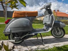 a motor scooter parked on the side of a road next to a house