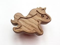 a wooden toy horse on a white surface