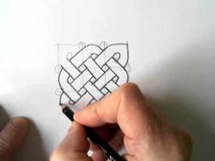 someone is drawing an intricate knot on paper