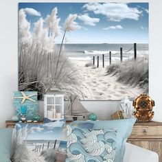 a beach scene with sea oats and blue pillows on a bed in front of the ocean