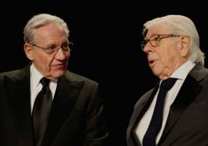 two older men in suits and ties sitting next to each other