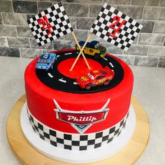 a birthday cake decorated with cars and checkered flags