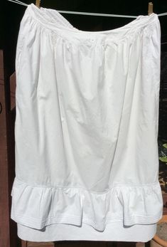 1900s french white cotton gathered full petticoat underskirt skirt with adjustable waist size monogram letters C B in red thread embroidered on the centre front waistband. The petticoat has a flounced hem and a straight dust ruffle which shows below the outer flounce.  The waist was made to be adjustable and extends from being 30 inches when the 2 tapes at the back are pulled fully in to 40 inches when the tapes are fully loosened. The waistband casing is in two parts one for each drawstring. Pu Daywear Ruffled Petticoat, Daywear Tiered Skirt Petticoat With Ruffles, Daywear Ruffled Tiered Skirt Petticoat, Daywear Tiered Petticoat With Ruffles, White Regency Style Petticoat With Ruffles, Cotton Petticoat With Gathered Skirt For Daywear, Regency Style Ruffled Petticoat For Daywear, Daywear Tiered Gathered Petticoat, Cotton Skirt With Ruffle Hem For Daywear