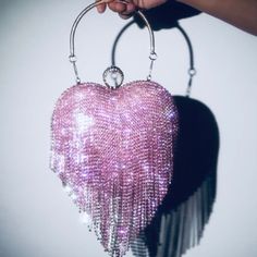 Introducing our Heart Shaped glitter diamond tassel handbag, a perfect accessory for a night out with the ladies or on a date. This elegant evening purse is designed to make a statement and show off your love for major bling. The bag is made of high-quality materials and is built to last. The glittery exterior sparkles so bright that it will catch everyone’s attention. The bag is available in two colors: “Passion Pink Punanny” and “Gold Digger Diamond”. The Details: The bag is heart-shaped and c Luxury Heart-shaped Party Shoulder Bag, Trendy Heart-shaped Evening Bags, Glamorous Heart-shaped Evening Bag, Pink Rectangular Rhinestone Bag, Pink Heart-shaped Evening Bag, Nicki Minaj Outfits, Sparkly Bag, Glitter Purse, Heart Shaped Bag