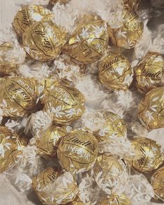 gold foiled chocolate candies are sitting on plastic wrap