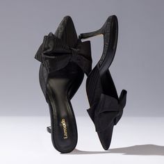 An ode to vintage slippers, the Mini Elle Pump is provocative and prim all at once. With a hand-knotted bow, they're sweet up front with a sexy heel at last glance. Luxury Heels With Satin Bow And Pointed Toe, Formal Slip-on Heels With Bow, Evening Mules With Bow And Pointed Toe, Evening Slip-on Heels With Sculpted Heel, Pointed Toe Bow Mules For Party, Party High Heel Mules With Bow, Party Bow Mules With Pointed Toe, Party Mules With Bow And Pointed Toe, Chic High Heel Mules With Bow