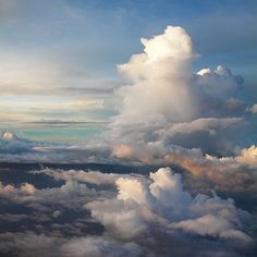 the view from an airplane looking down at some clouds in the sky and on top of another cloud