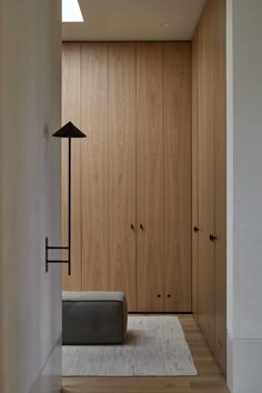 an empty room with wood paneling and a light fixture on the wall next to it