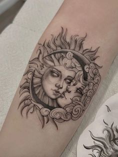 a woman's arm with a sun and moon tattoo on it