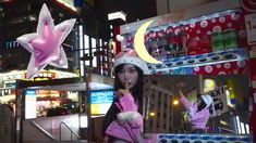 a woman wearing a pink coat and white hat standing in front of a store display